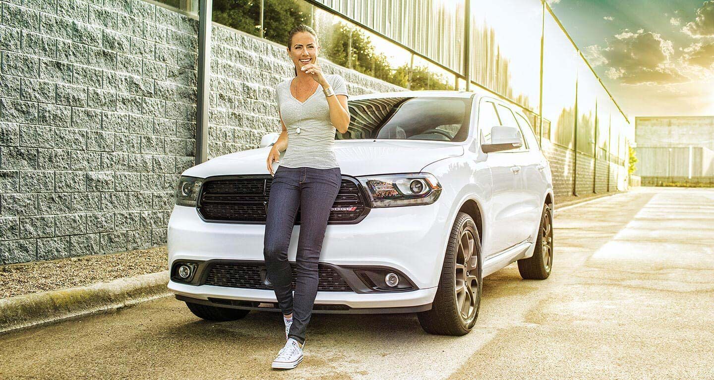 Mostrar: Una mujer posando en frente de un Dodge Durango 2020.