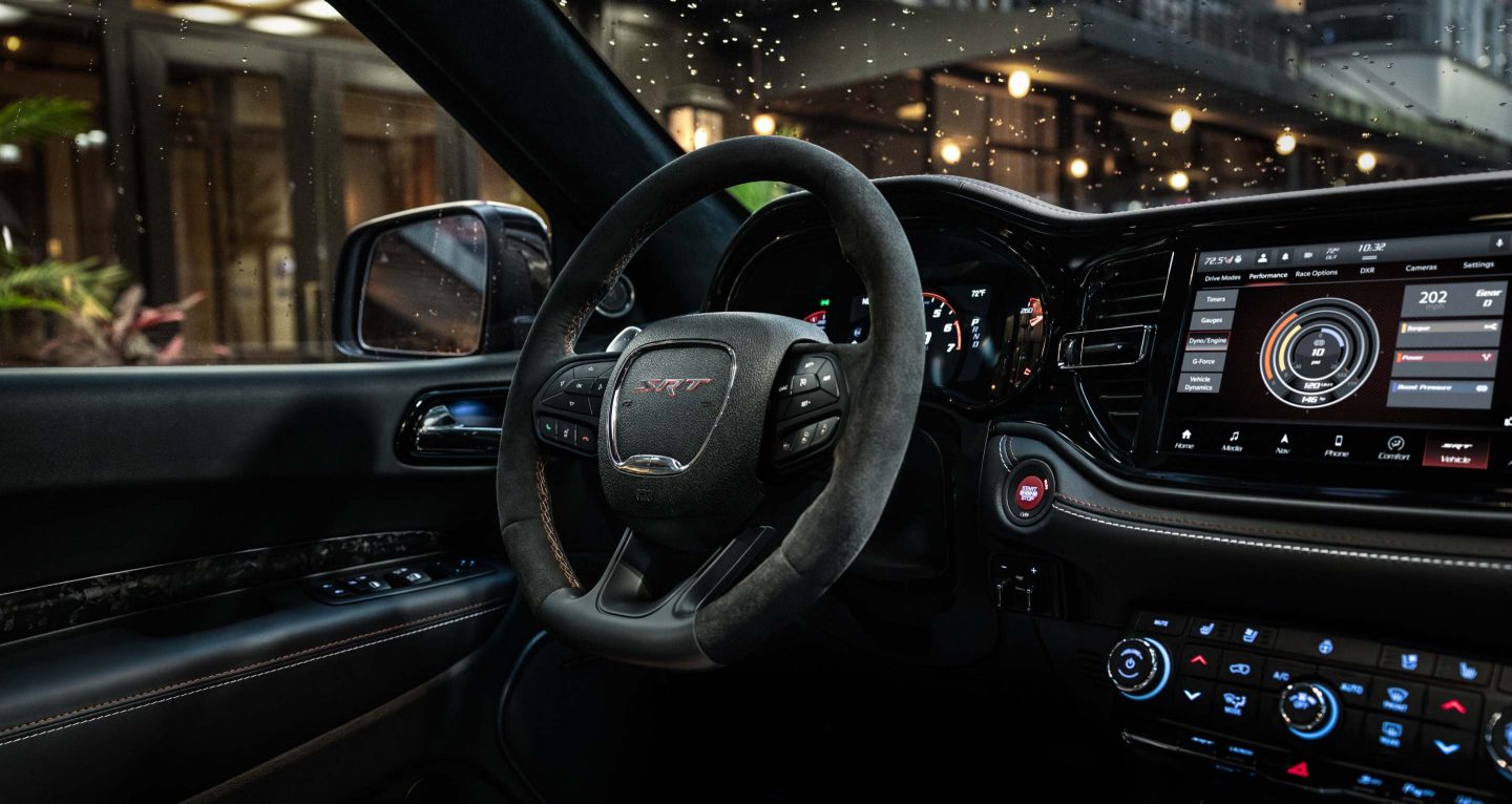 Se muestra: el volante y la pantalla táctil Uconnect en un Dodge Durango SRT Hellcat 2026.