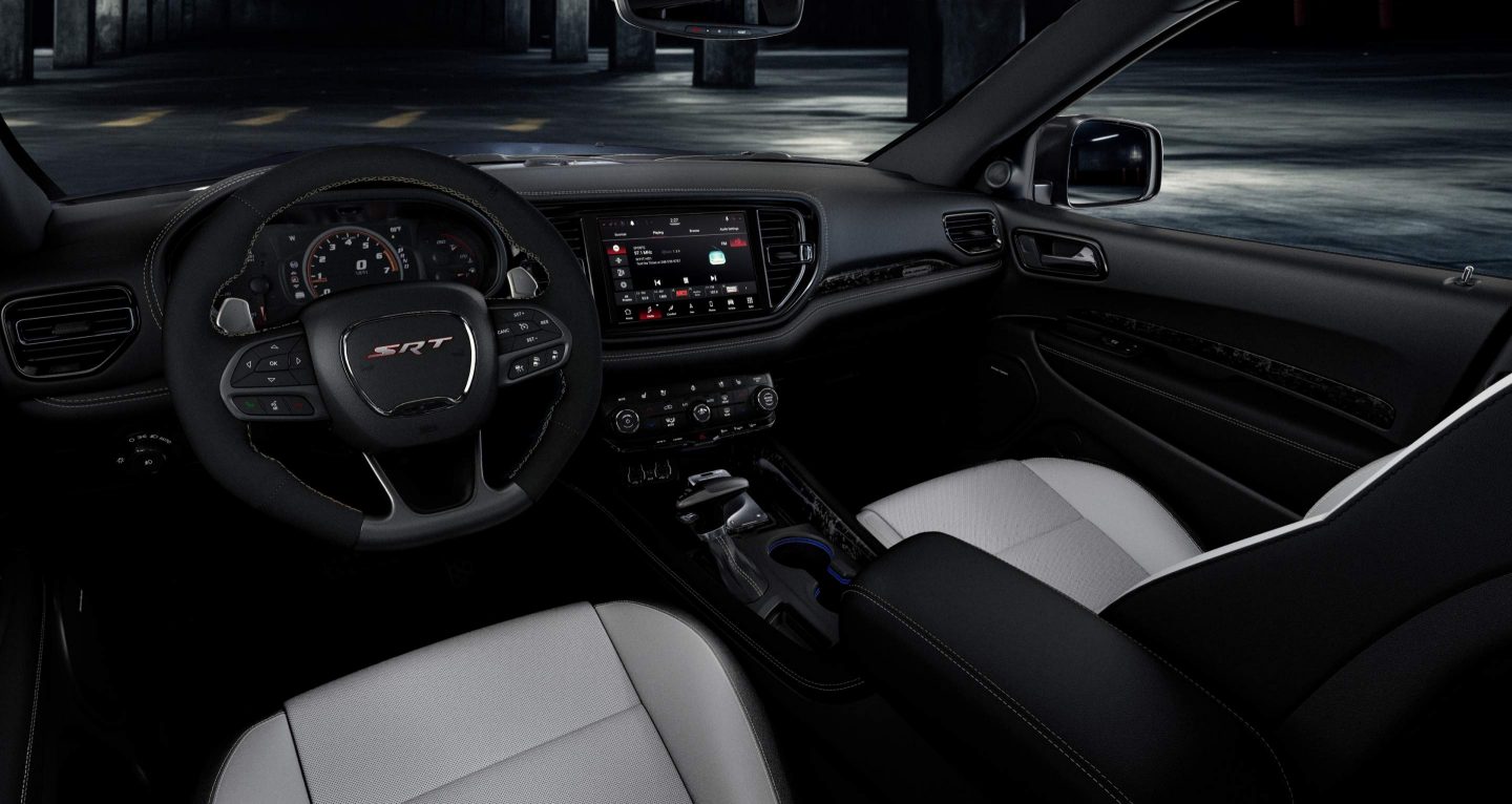 Se muestra: el volante, la pantalla digital en el panel de instrumentos, la pantalla táctil Uconnect y los asientos delanteros en un Dodge Durango SRT Hellcat 2026.