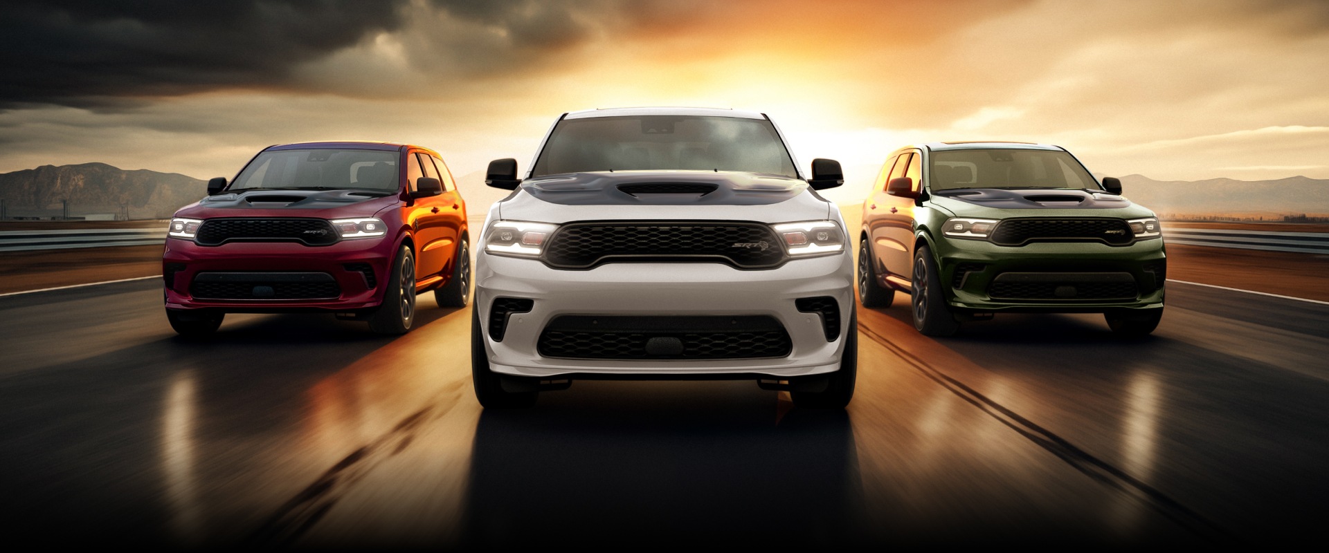 Tres modelos Dodge Durango 2026 circulando por una pista al atardecer. De izquierda a derecha: un Dodge Durango SRT Hellcat, un Dodge Durango SRT Hellcat blanco y un Dodge Durango SRT Hellcat verde.