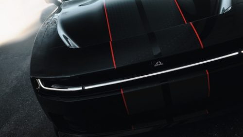 The hood and front end of a black  2027 Dodge Charger Scat Pack with dual black and red center stripes.