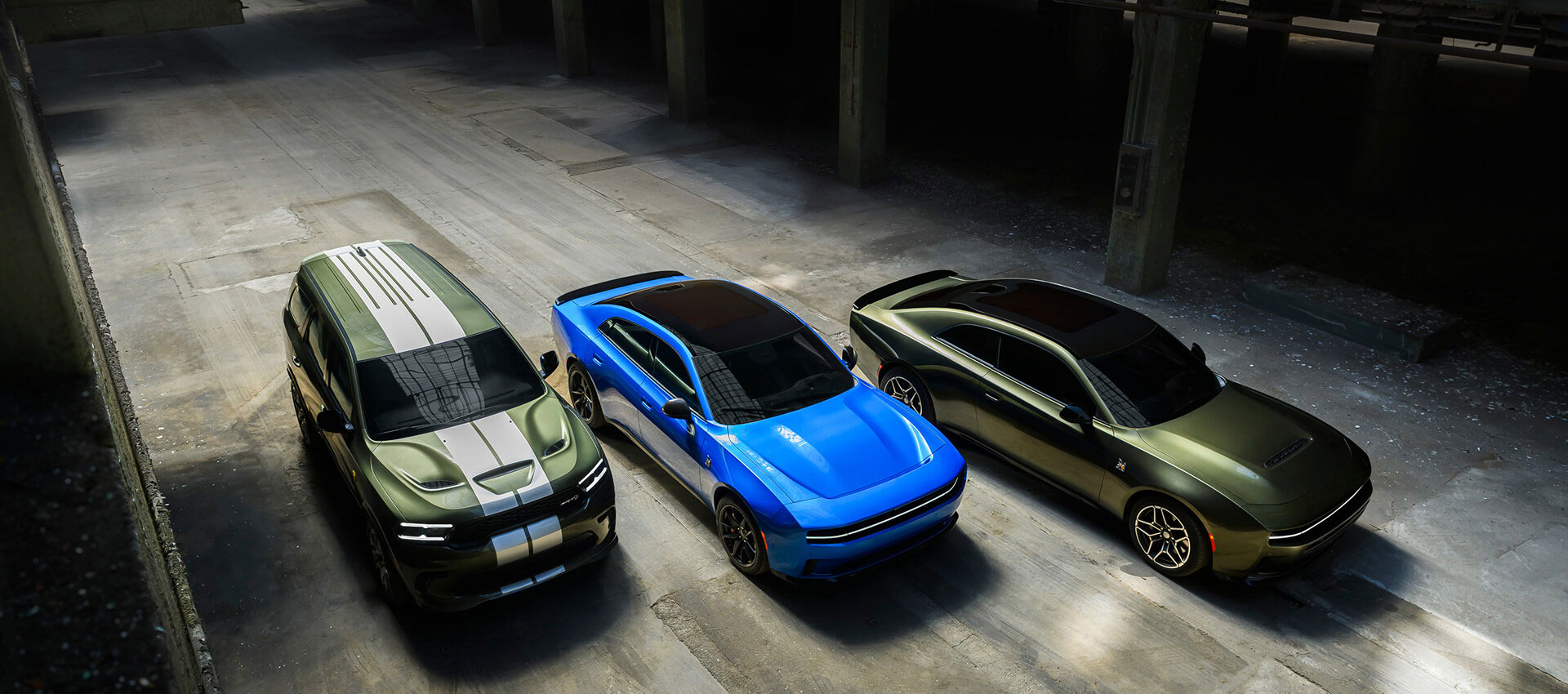 De izquierda a derecha: un Durango SRT Hellcat verde con dos franjas centrales blancas, un Charger Daytona Scat Pack azul y un Charger Scat Pack verde.